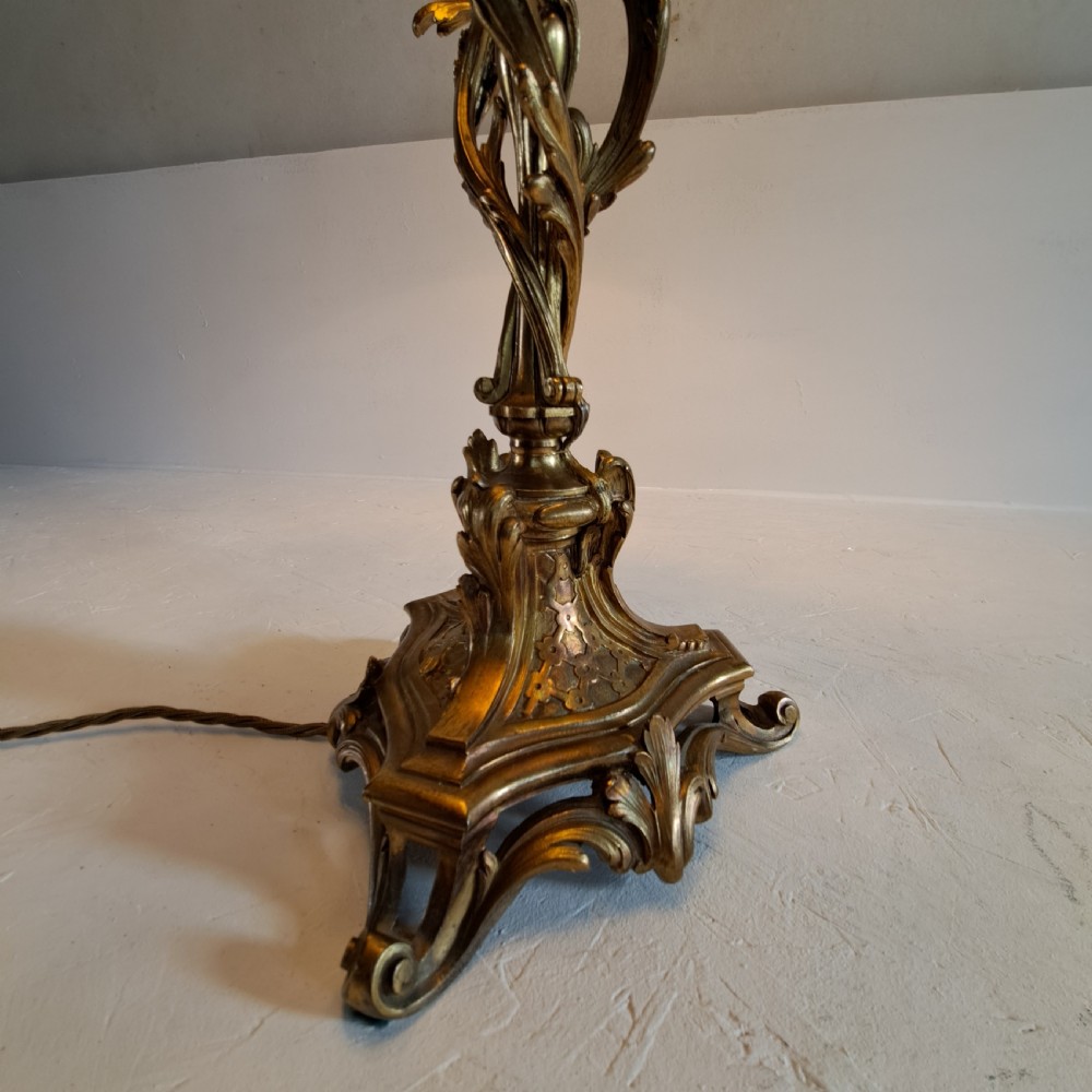 An ornate four-light gilt bronze candelabra table lamp in Rococo Revival style with flared fabric shades and cast scrollwork. View II