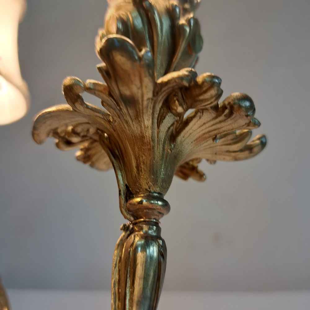 An ornate four-light gilt bronze candelabra table lamp in Rococo Revival style with flared fabric shades and cast scrollwork. View VI