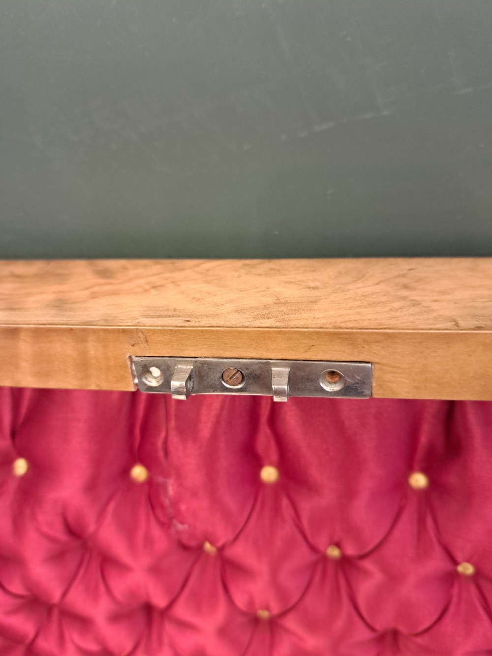 A rectangular blonde walnut jewellery box with a brass keyhole escutcheon and recessed handle on the lid, resting on a dark marble surface. View XIX
