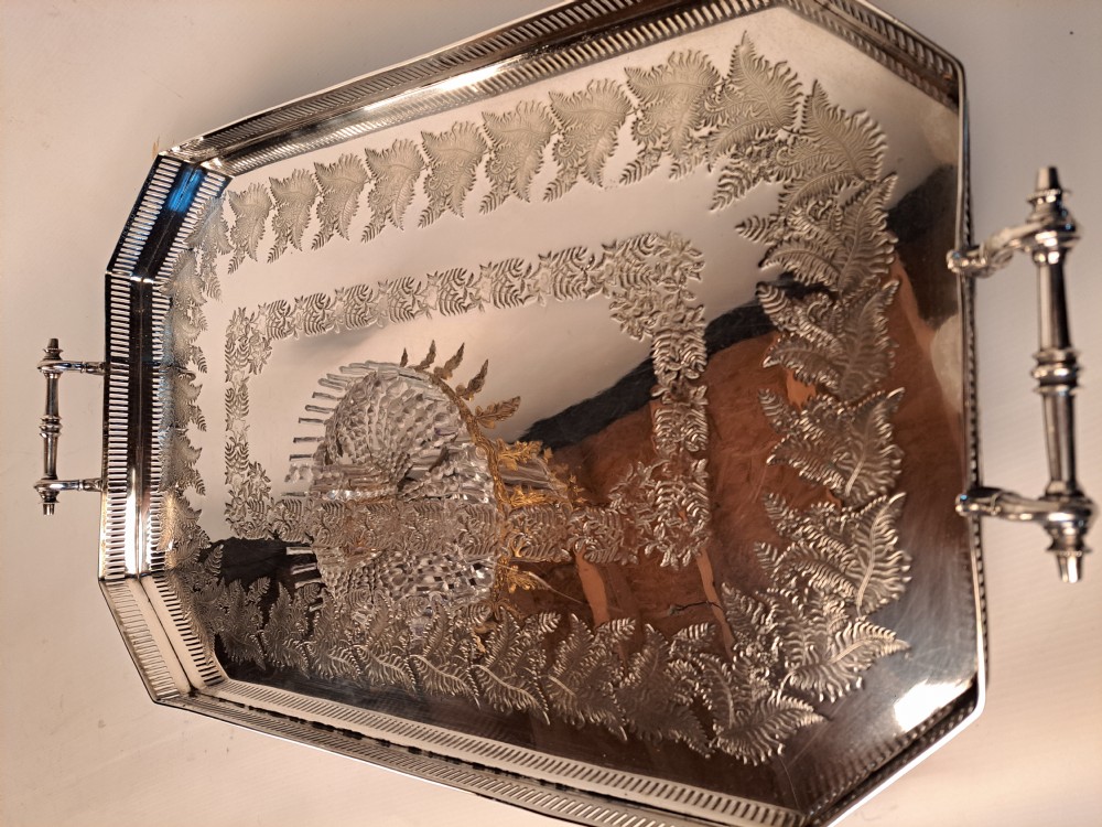 An antique silver plated rectangular gallery tray featuring twin handles, a pierced lattice border, and engraved foliage across the surface.