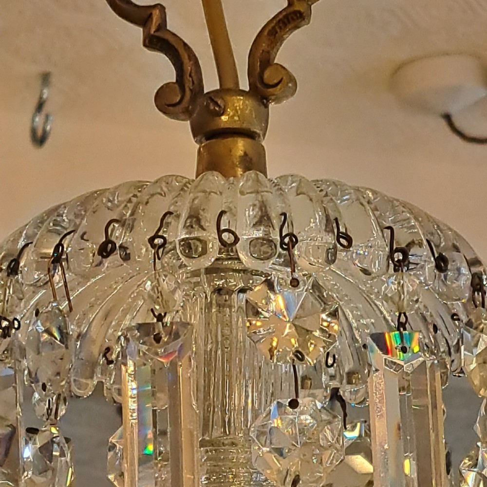 A multi-tiered antique crystal and gilt bronze electrolier chandelier with cascading prisms and candle-style bulb fittings. View XXIX