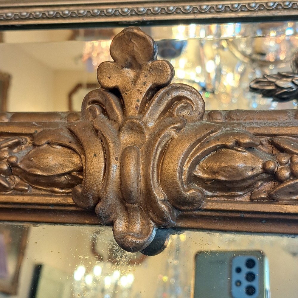 A large rectangular Georgian overmantel mirror featuring a rounded upper frame with gilded bead moulding and decorative foliate corner scrolls. View VI