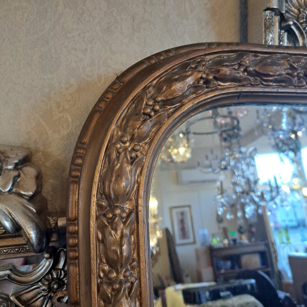 A large rectangular Georgian overmantel mirror featuring a rounded upper frame with gilded bead moulding and decorative foliate corner scrolls. View VIII