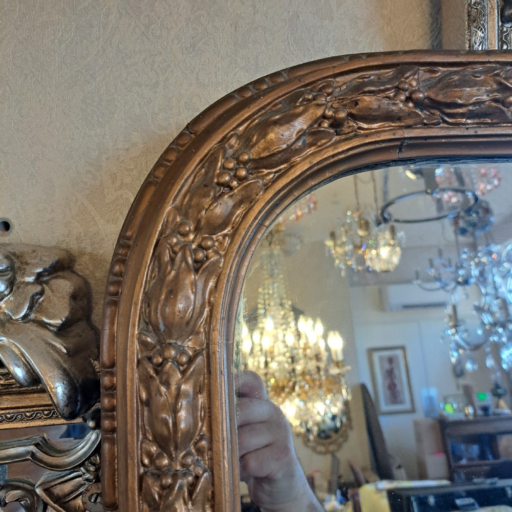 A large rectangular Georgian overmantel mirror featuring a rounded upper frame with gilded bead moulding and decorative foliate corner scrolls. View IX