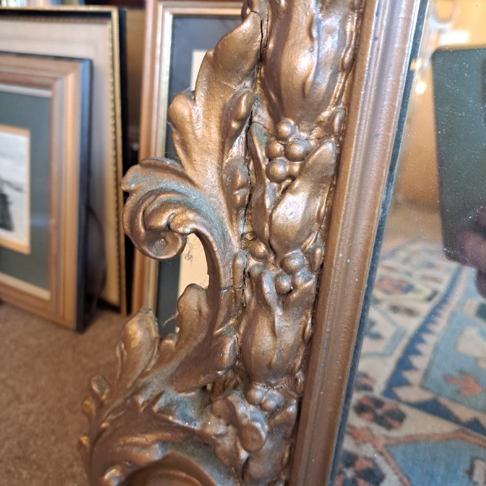 A large rectangular Georgian overmantel mirror featuring a rounded upper frame with gilded bead moulding and decorative foliate corner scrolls. View X