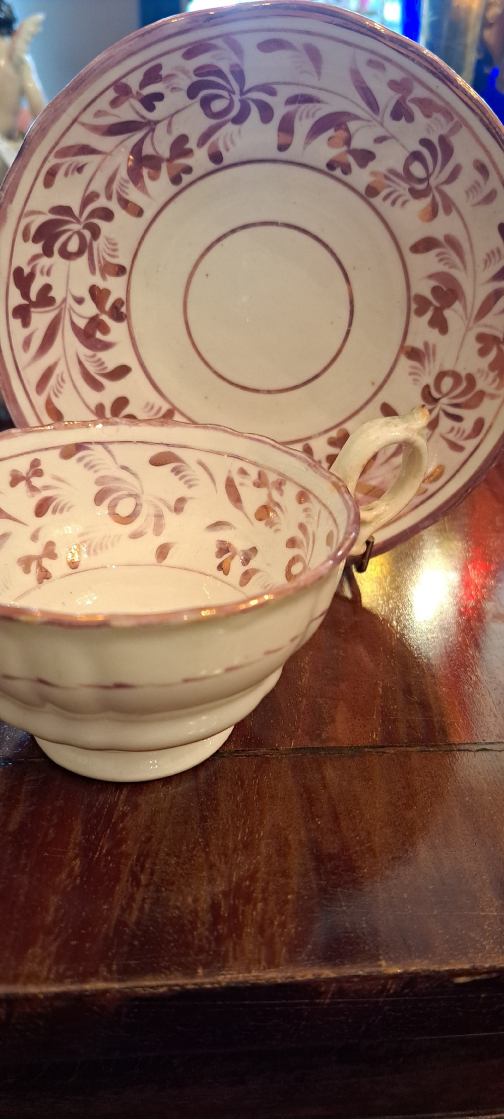A set of six antique pink lustreware teacups with matching saucers featuring hand-painted botanical foliage patterns on a cream ceramic background. View II