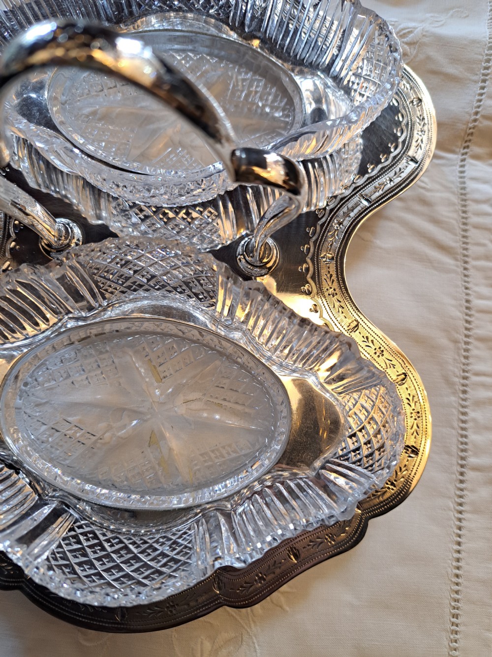 An Edwardian silver-plated relish caddy featuring a central carrying handle and two fitted cut-glass dishes with geometric patterns. View III