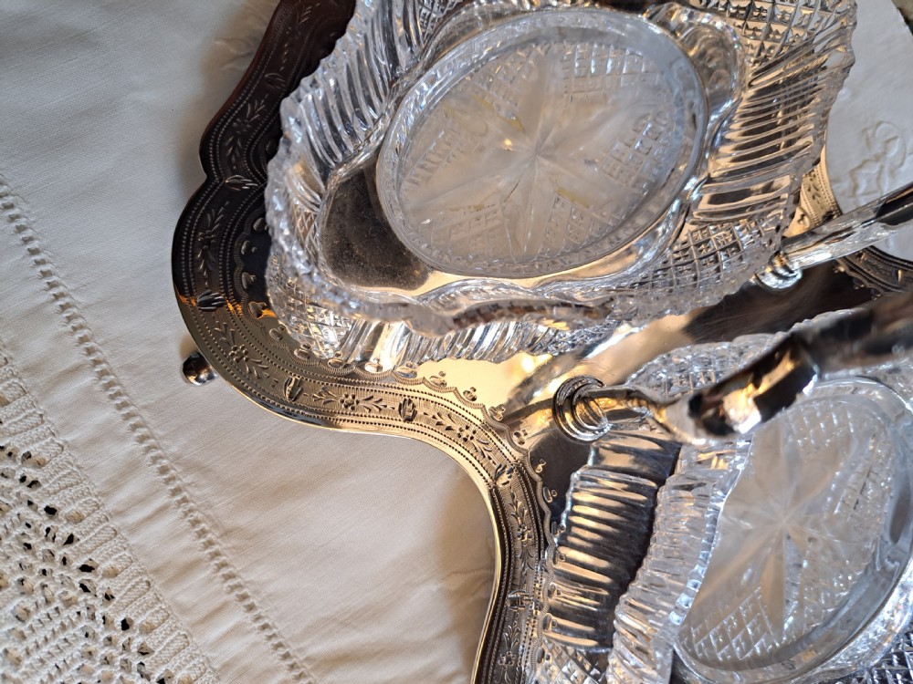 An Edwardian silver-plated relish caddy featuring a central carrying handle and two fitted cut-glass dishes with geometric patterns. View IV