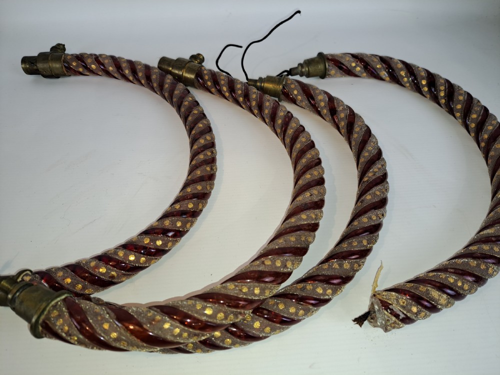 A set of four curved Bohemian ruby glass chandelier arms featuring twisted spiral patterns highlighted with gold enamelled dots and brass threaded mounts. View VI
