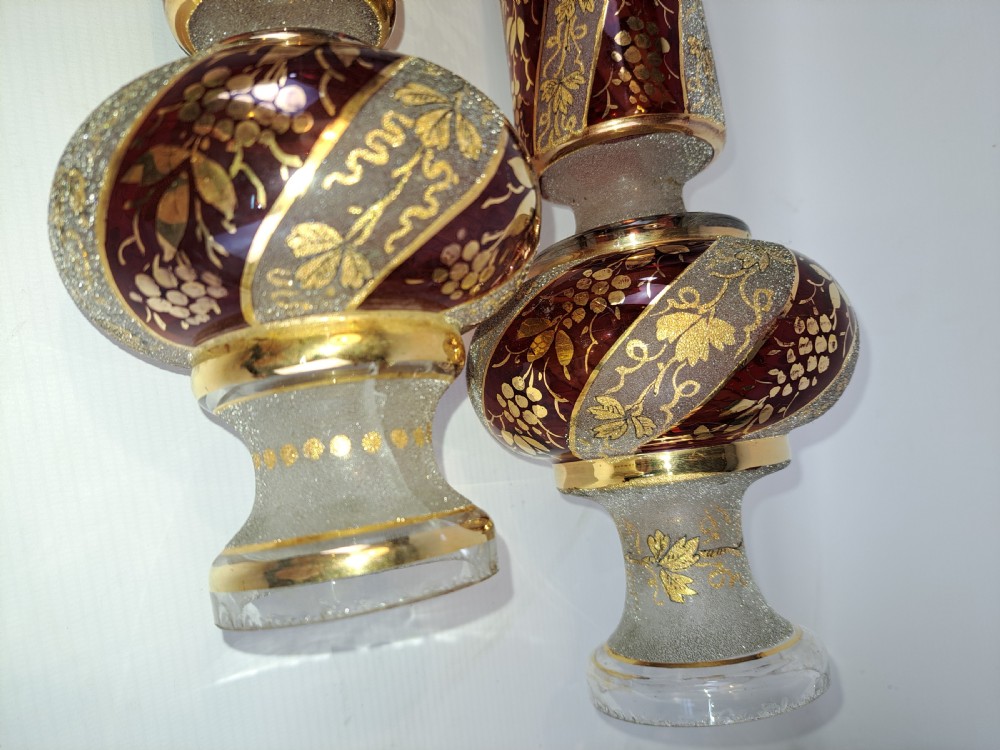 A pair of antique ruby red and frosted glass chandelier stems decorated with spiral gilt grapevine patterns. View II