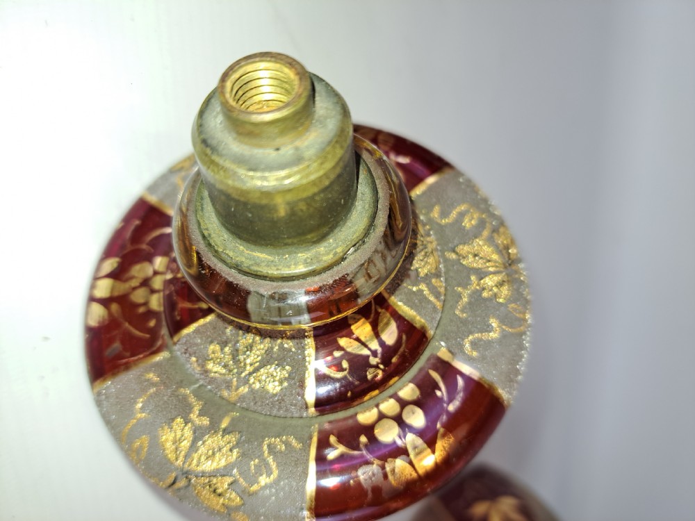An antique Bohemian ruby glass finial featuring gold leaf floral etching, frosted glass texturing, and a brass threaded mount. View II