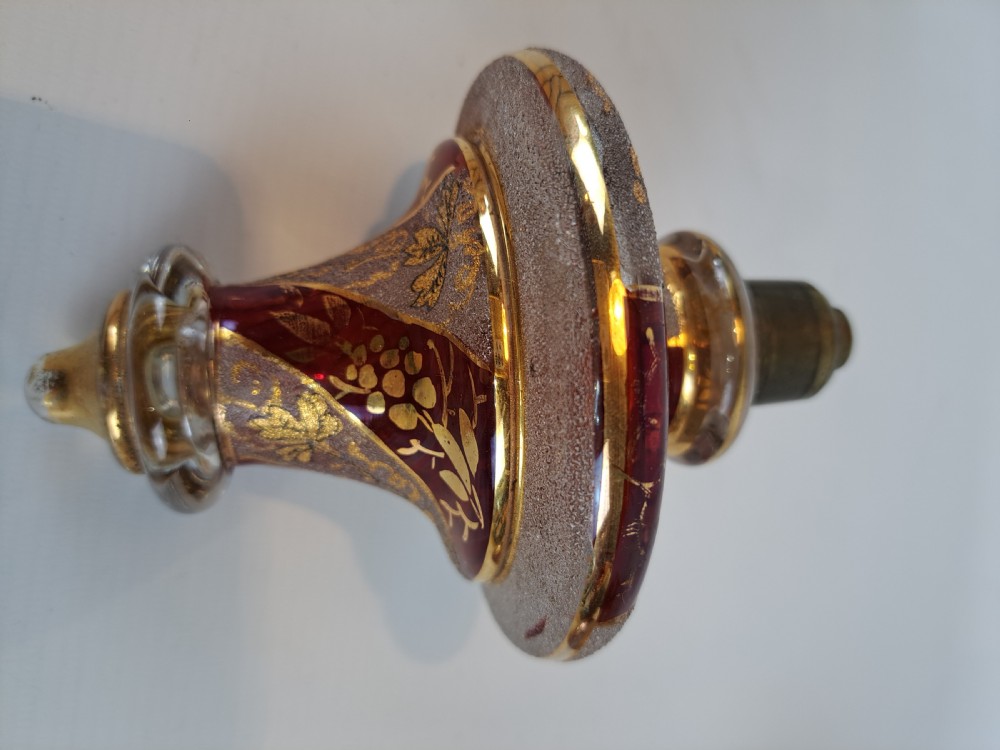 An antique Bohemian ruby glass finial featuring gold leaf floral etching, frosted glass texturing, and a brass threaded mount. View V