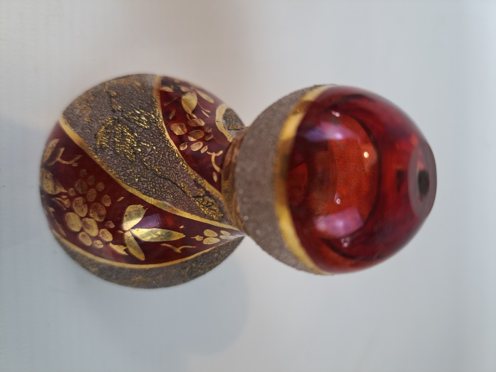 A pair of ruby red glass decorative bells featuring hand-painted gold foliage motifs and textured gilded bands. View V