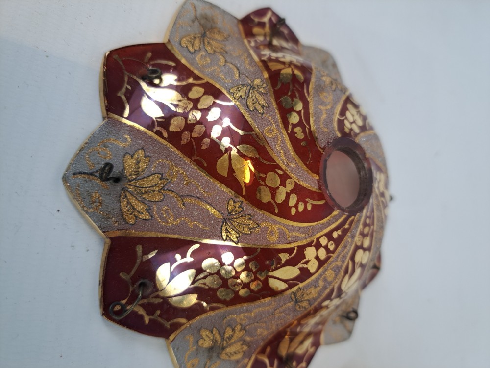 A pair of scalloped Bohemian ruby glass bobeches with frosted panels, hand-painted gold leaf vine patterns, and small metal wire loops. View IV