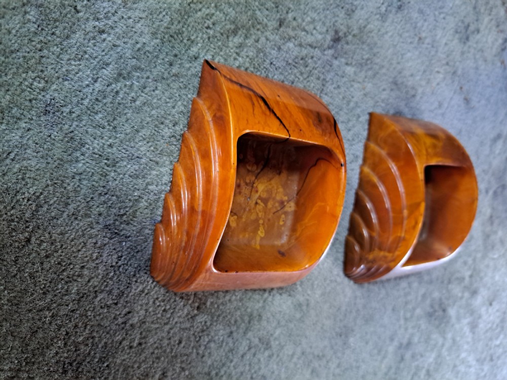 A pair of Art Deco amber phenolic resin stamp wetters featuring stepped side motifs and hollowed rectangular wells. View VII
