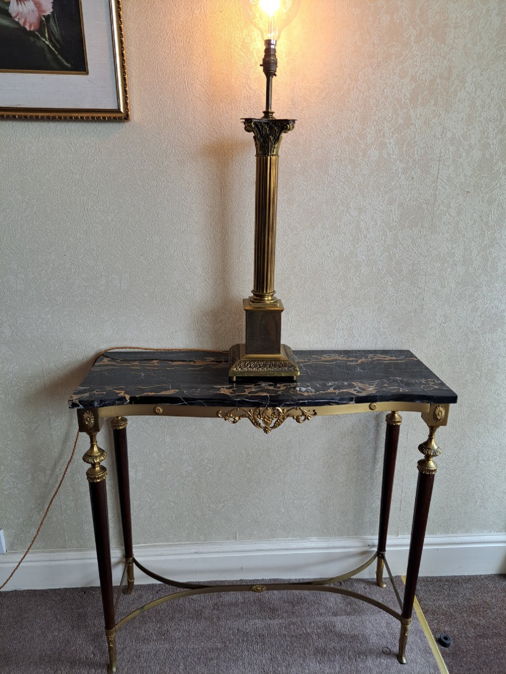 A brass table lamp designed as a classical Corinthian column with a fluted shaft and stepped square base.