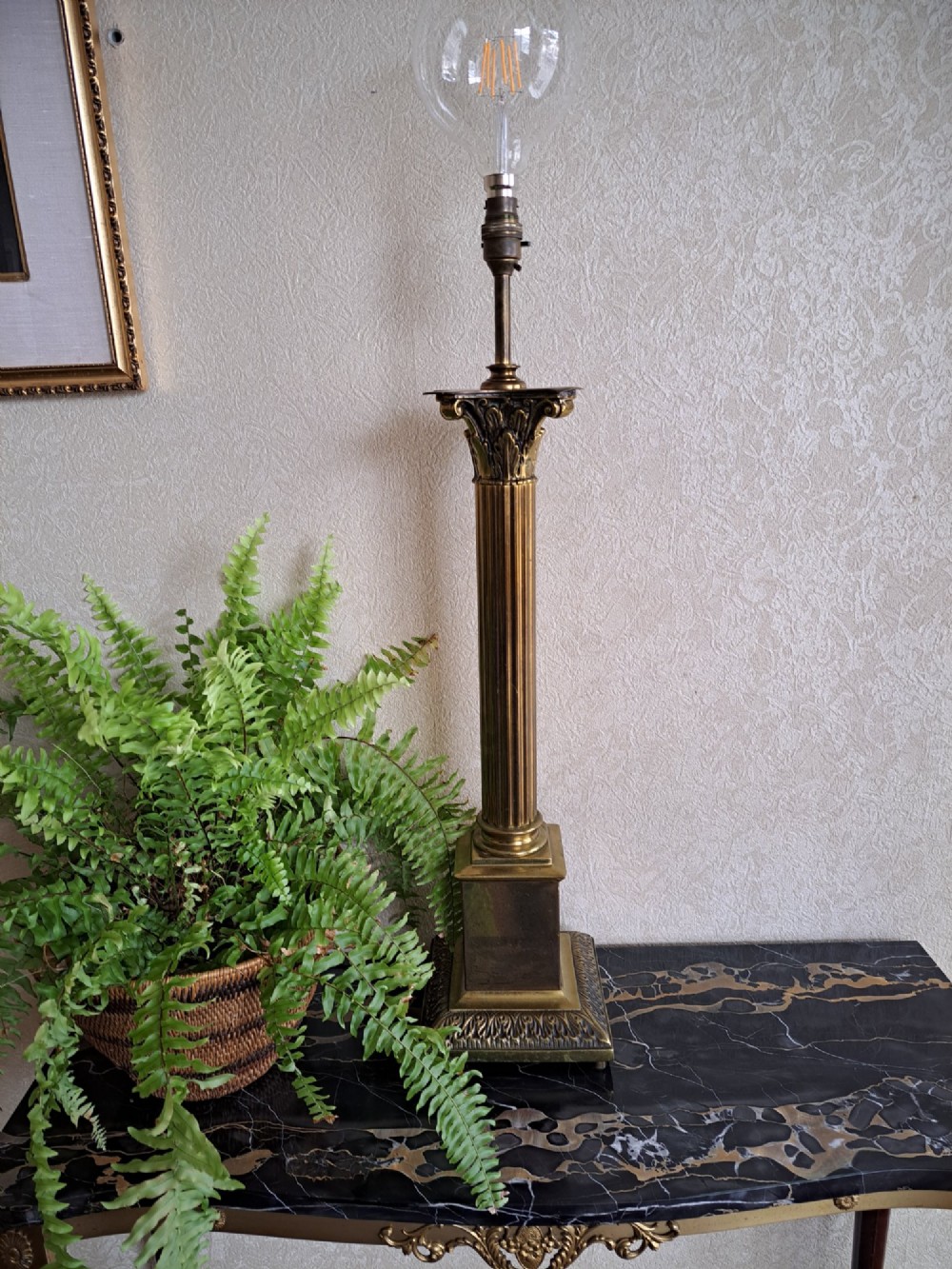 A brass table lamp designed as a classical Corinthian column with a fluted shaft and stepped square base. View IX