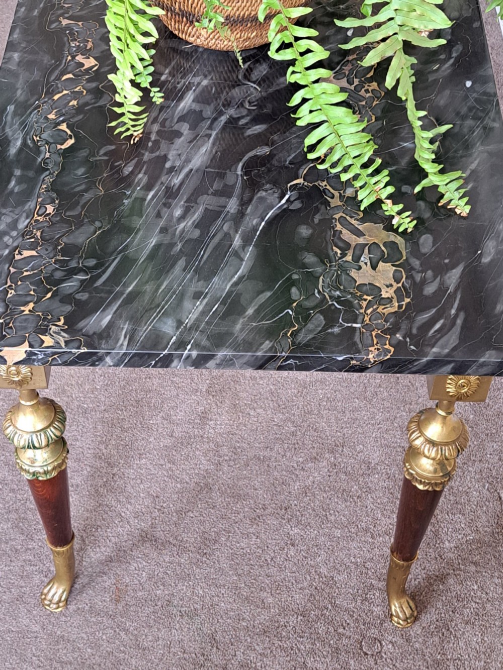 A rectangular coffee table featuring a dark veined marble top supported by tapered legs with ornamental brass mounts and brass feet. View V