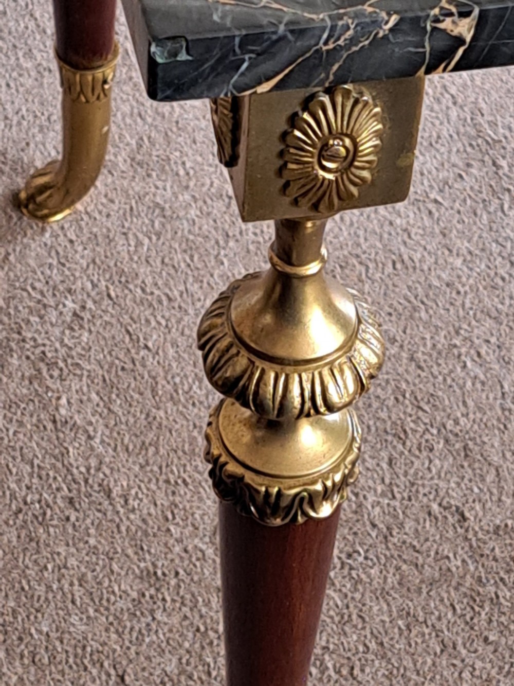 A rectangular coffee table featuring a dark veined marble top supported by tapered legs with ornamental brass mounts and brass feet. View VIII