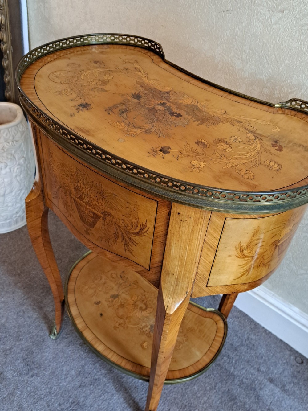 A kidney-shaped French marquetry side table featuring floral timber inlays, two drawers, a pierced brass gallery top, and a lower shelf. View IV