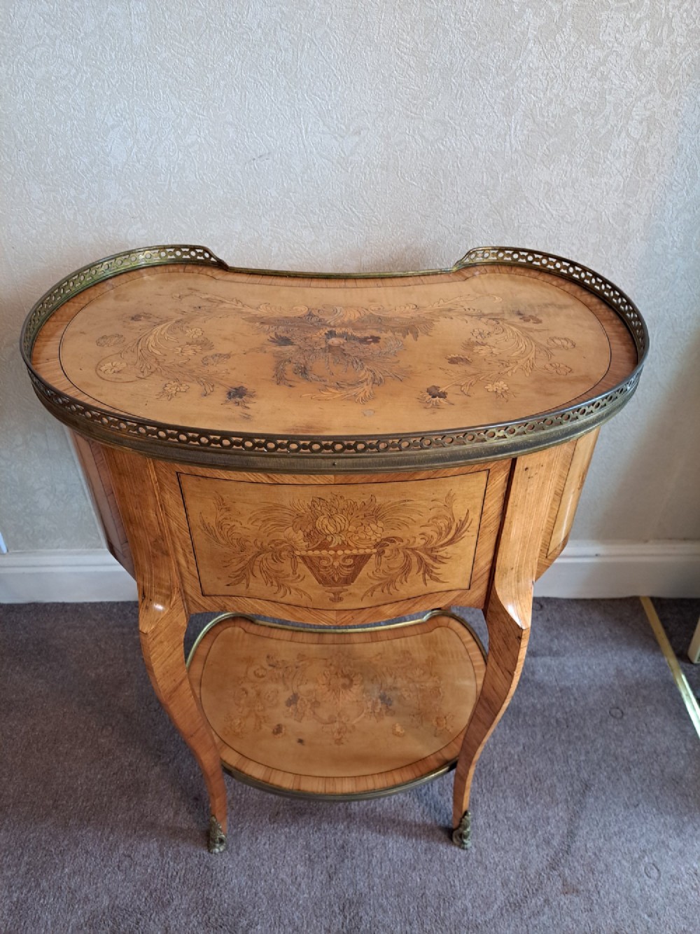 A kidney-shaped French marquetry side table featuring floral timber inlays, two drawers, a pierced brass gallery top, and a lower shelf. View X