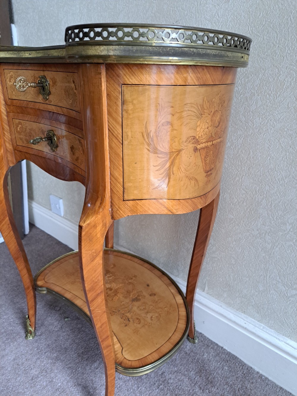 A kidney-shaped French marquetry side table featuring floral timber inlays, two drawers, a pierced brass gallery top, and a lower shelf. View XII