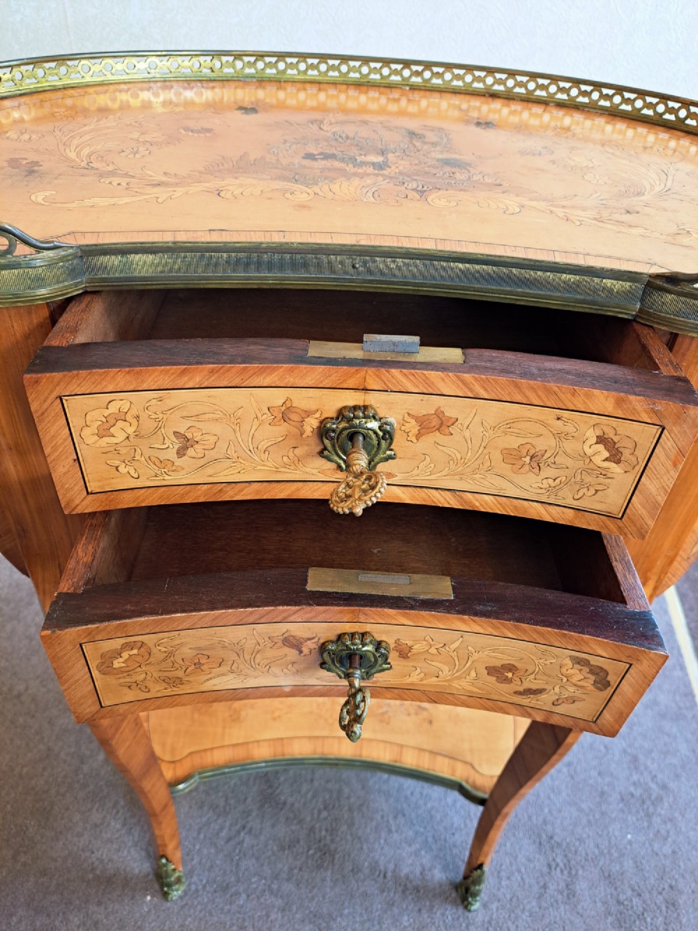 A kidney-shaped French marquetry side table featuring floral timber inlays, two drawers, a pierced brass gallery top, and a lower shelf. View XIII