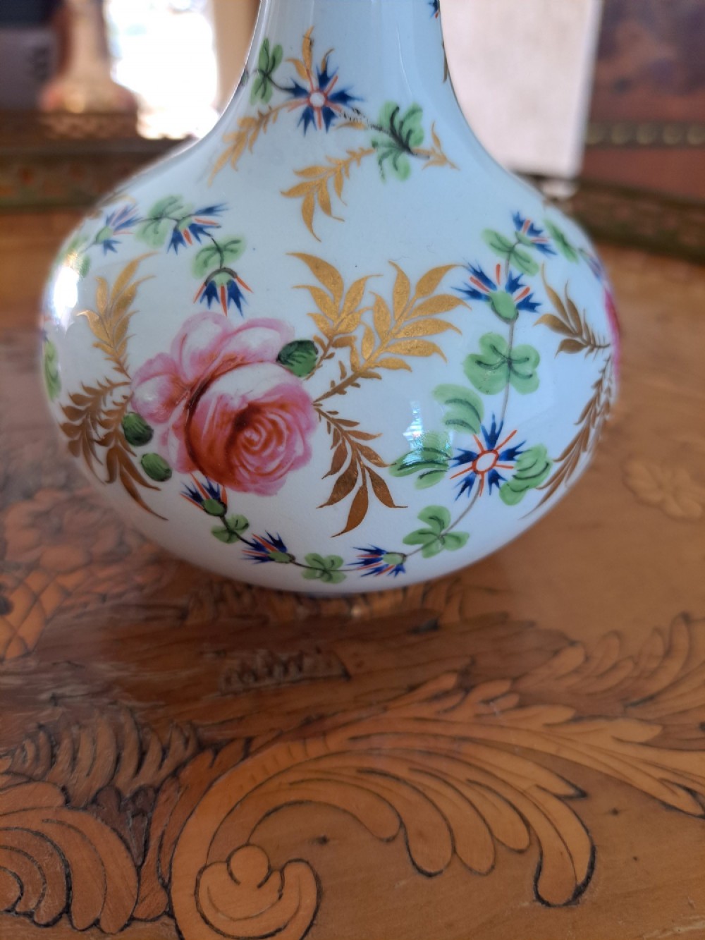 A pair of white porcelain bud vases featuring hand-painted floral motifs in pink, blue, and green with gilded rims and leaf accents. View VI