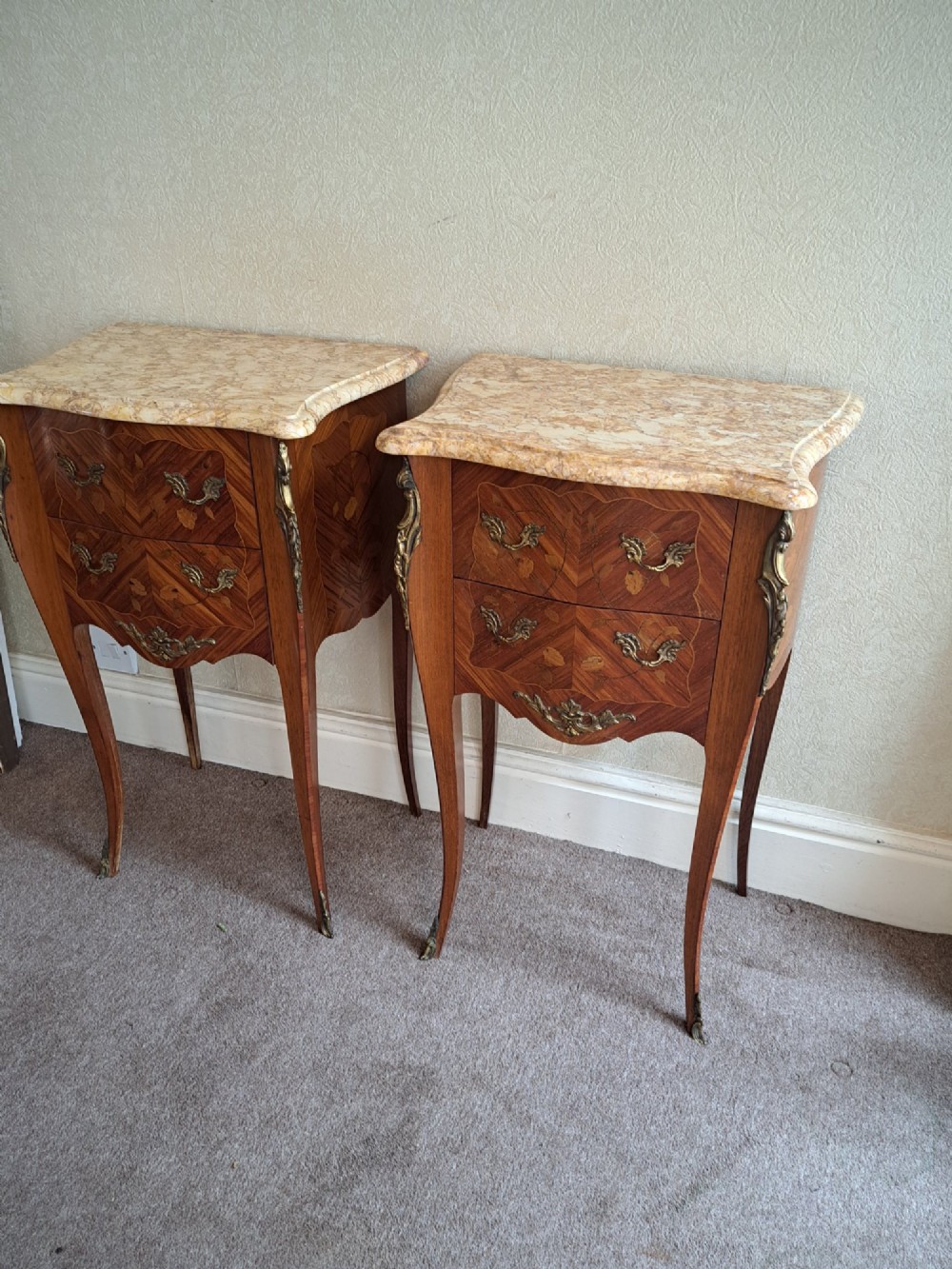 A pair of French style bedside tables featuring contoured beige marble tops, floral marquetry veneer drawers, brass handles, and sweeping cabriole legs. View III