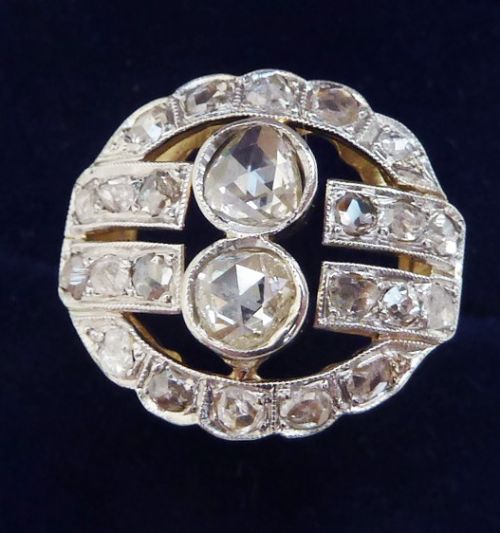 fig 1. An Edwardian oval-shaped 18ct gold ring featuring a cluster of rose-cut diamonds set with millegrain details.
