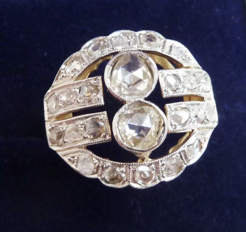 fig 2. An Edwardian oval-shaped 18ct gold ring featuring a cluster of rose-cut diamonds set with millegrain details.