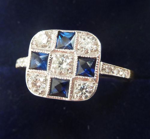 fig 1. An Art Deco 18ct white gold square panel ring set with four square blue sapphires, five diamonds, and millegrain detailing.