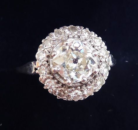 fig 1. An Art Deco platinum ring featuring a large centre diamond surrounded by a halo cluster of smaller round diamonds.