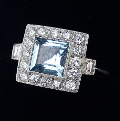 fig 1. Art Deco platinum ring featuring a central square-cut aquamarine framed by a square halo of brilliant diamonds with millegrain detailing and baguette diamonds on the shoulders.
