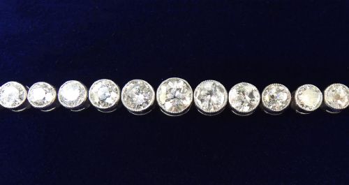 fig 1. An Art Deco platinum line bracelet set with a row of graduated round diamonds in rub-over bezel settings.