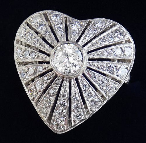 fig 1. An Art Deco platinum heart-shaped ring set with a central round diamond surrounded by radiating rows of smaller diamonds with millegrain detailing.