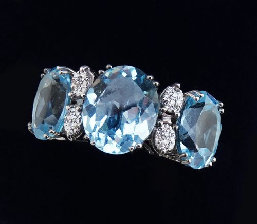 fig 1. An 18ct white gold Art Deco style ring featuring three oval light blue aquamarine gemstones with small pave diamond accents set between them.