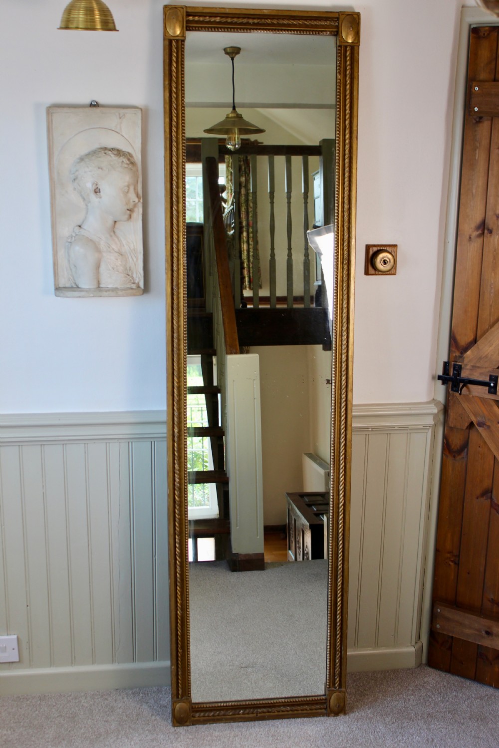 A tall rectangular antique giltwood pier mirror featuring rope-twist moulding and rosette corner blocks.