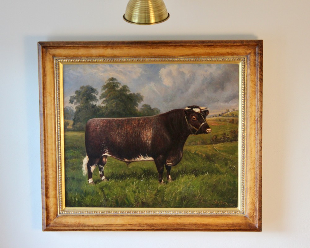 A framed oil painting displaying a brown and white Shorthorn bull standing in profile within a green pasture under a cloudy sky. View IV