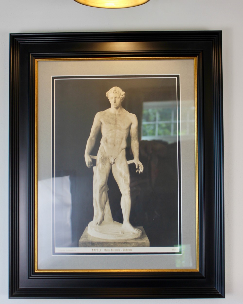 A pair of black and white framed photographic prints depicting ancient classical statues from the Naples National Archaeological Museum in dark stepped frames with gold accents. View VI