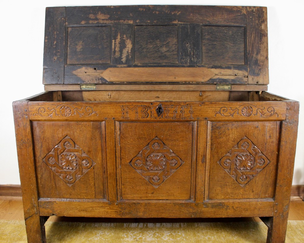 A dark oak coffer featuring three carved front panels with geometric lozenge motifs and a panelled hinged lid. View VIII