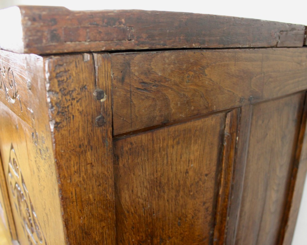 A dark oak coffer featuring three carved front panels with geometric lozenge motifs and a panelled hinged lid. View XI