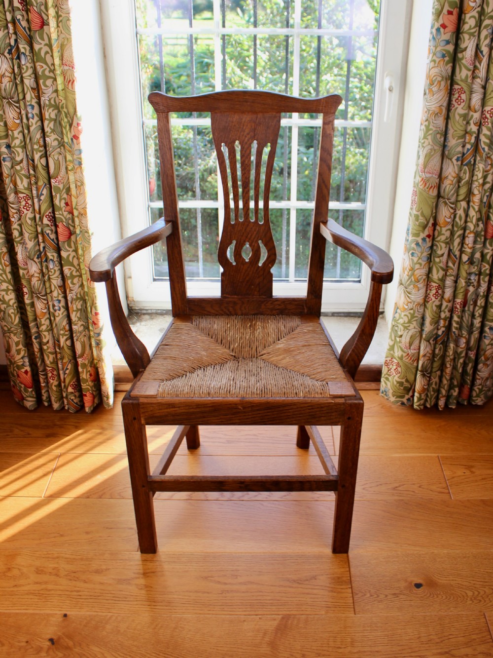 A set of eight George III oak country dining chairs with pierced splat backs and woven rush seats. View IX