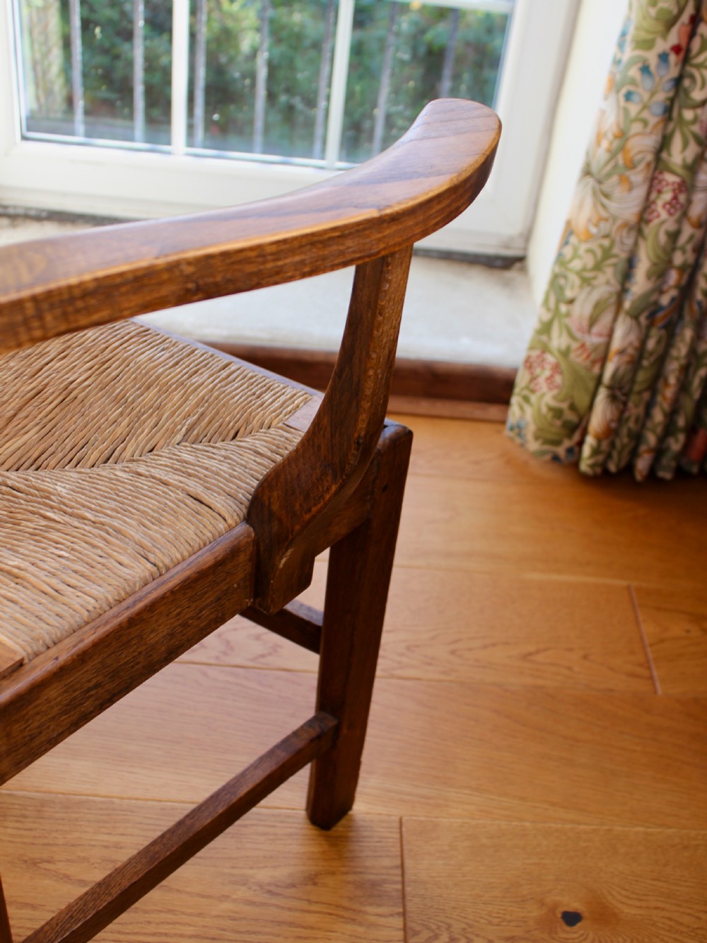 A set of eight George III oak country dining chairs with pierced splat backs and woven rush seats. View XII
