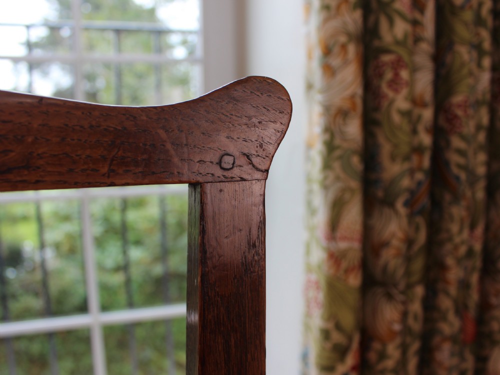 A set of eight George III oak country dining chairs with pierced splat backs and woven rush seats. View XIII