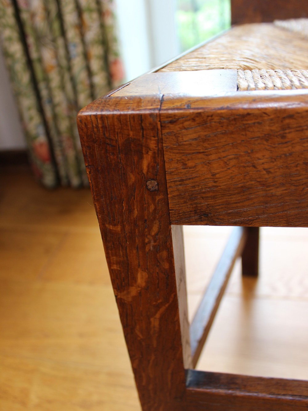 A set of eight George III oak country dining chairs with pierced splat backs and woven rush seats. View XIV