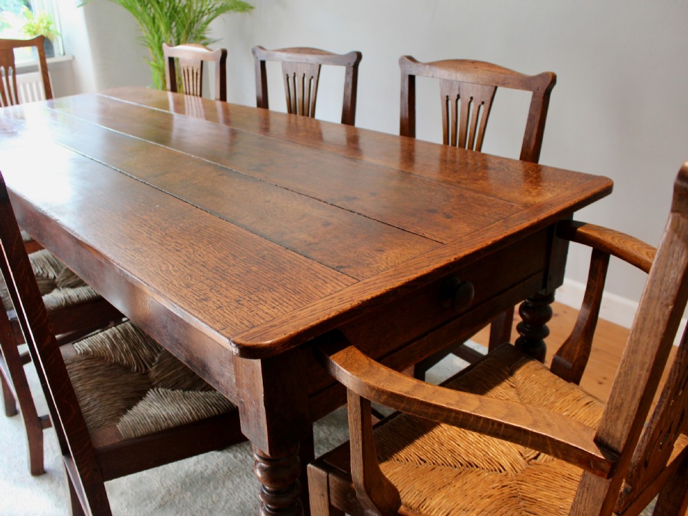 A set of eight George III oak country dining chairs with pierced splat backs and woven rush seats. View XV