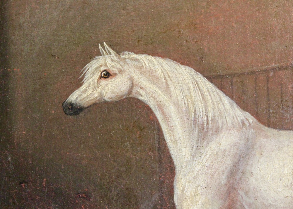 An early 19th-century oil painting depicting a white stallion in profile inside a dimly lit stable, presented in a black ebonised frame with a gilded inner slip. View III