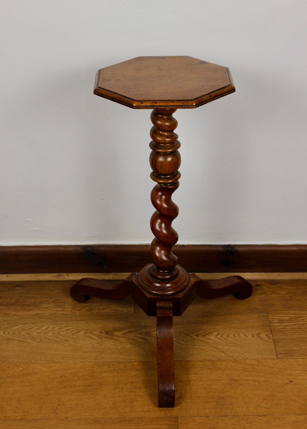 An antique William and Mary walnut candle stand featuring an octagonal top, a central barley-twist column, and a tripod base. View II