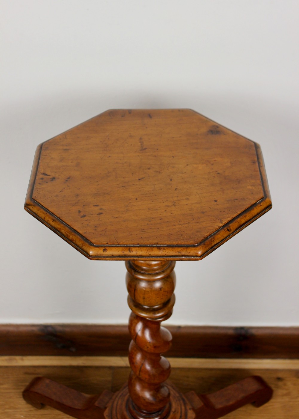 An antique William and Mary walnut candle stand featuring an octagonal top, a central barley-twist column, and a tripod base. View III